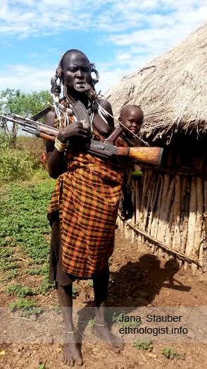 Mursi Woman with a Lip Plate, Gun and Child. 