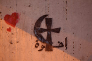 Interreligious dialogue and peace captured in streets in Cairo at the night. On the wall you can see Arabic word 'iida'atan (light). Photo: Barbora Sajmovicova, 2011. 